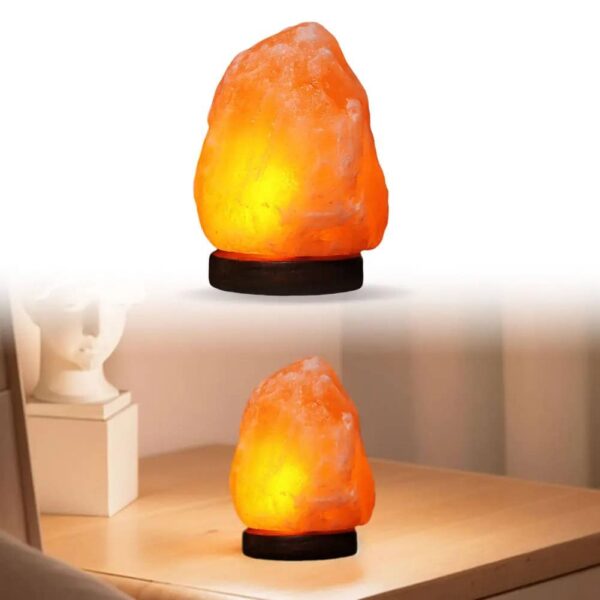 Himalayan salt lamp emitting warm orange glow, placed on a wooden surface in a cozy room setting.