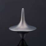 A metallic spinning top toy demonstrating rotational physics, perfect for educational science experiments and science decor.