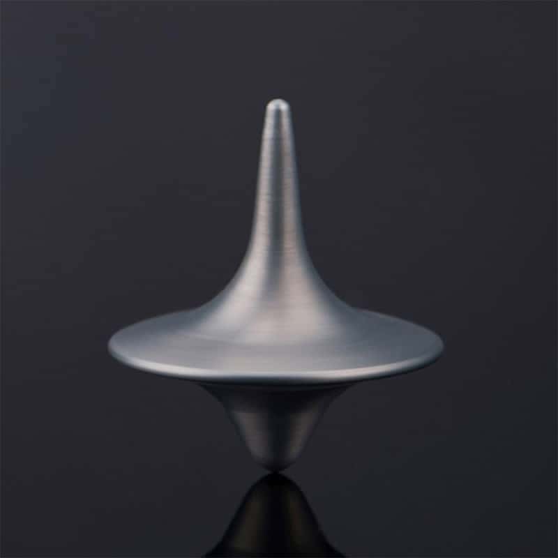 A metallic spinning top toy demonstrating rotational physics, perfect for educational science experiments and science decor.