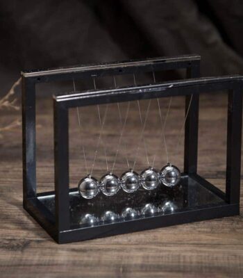 Newton's Cradle desktop physics toy with five metallic spheres demonstrating conservation of momentum and energy. Perfect for science enthusiasts, educational settings, and modern decor.