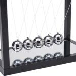 Newton's Cradle with five shiny metallic balls demonstrating conservation of momentum and energy.