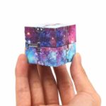 Hand holding a cosmic galaxy-themed puzzle cube with a galaxy print design, featuring vibrant colors and star patterns, perfect for science decor and educational toys.