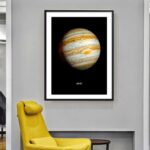 Jupiter planet poster framed on a wall in a contemporary room with a yellow armchair below.
