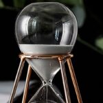Elegant glass hourglass with a metallic stand, perfect for science-themed decor and educational displays.