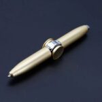 A sleek gold-colored mechanical pen featuring a ring clip, ideal for science gadgets, educational demonstrations, and scientific note-taking.