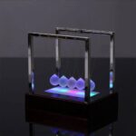 Modern Newton's Cradle with glowing LED spheres, demonstrating physics principles and kinetic energy transfer, perfect for educational and decorative purposes.