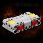 Portable LEGO-style electrical circuit block with red, yellow, and gray components on a dark background.