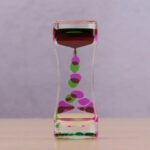 Colorful Liquid Timer with Floating Balls in Glass Container.