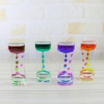 Brightly colored hourglass timers with liquid in pink, green, purple, and orange, demonstrating fluid dynamics and time measurement.