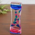 Colorful liquid density tower with layers of blue, pink, and clear liquids demonstrating different densities, perfect for educational science activities.