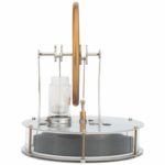 Educational physics demonstration device with rotating wheel and glass container.