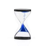 Clear glass sand timer with black caps, showing blue sand flowing from top to bottom, ideal for teaching time concepts and managing activities.