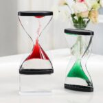 Elegant hourglass timers with red and green sand, perfect for educational demonstrations and home decor.