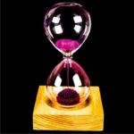 Sand timer with pink sand flowing between two glass bulbs on a wooden stand.