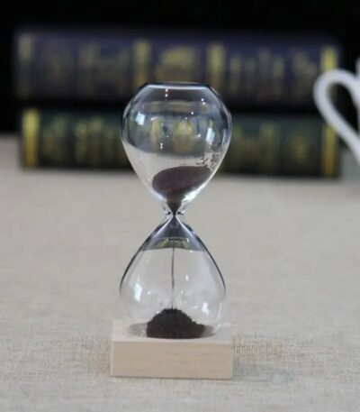 Classic glass hourglass with black sand, used for science experiments, educational demonstrations, and as a stylish decor piece.