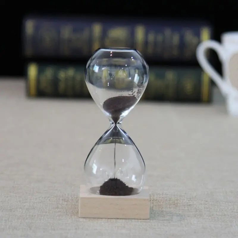 Sand Timer Hourglass for Science Education and Decor Classic glass hourglass with black sand, used for science experiments, educational demonstrations, and as a stylish decor piece.