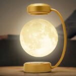 Decorative moon lamp with a glowing surface, mounted on a stylish gold stand, creating a celestial ambiance perfect for home decor or educational displays.