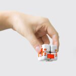 Hand holding a puzzle cube with medical cross symbols, demonstrating a science-themed educational toy.