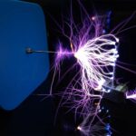 Close-up of a Tesla coil producing purple electrical arcs with sparks and lightning effects, demonstrating high-voltage electrical phenomena.