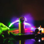 A person touching a plasma globe with colorful electric discharges emanating from the sphere, showcasing a captivating science demonstration.