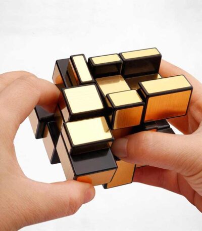 Hand holding a magnetic puzzle cube with black and gold-colored pieces, demonstrating a challenging brain teaser toy for cognitive development and problem-solving skills.