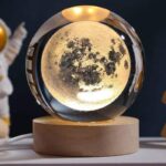 A moon globe lamp with a detailed lunar surface design, serving as an educational decor piece and night light. Perfect for science enthusiasts and space lovers.