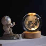 Decorative lunar globe with astronaut figurine for space enthusiasts and science lovers.