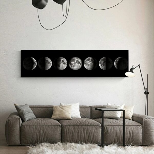 A sleek black wall art piece displaying the different phases of the moon, mounted above a contemporary gray sofa in a minimalist living room.