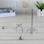 A metal pendulum set with spherical weights and a stand, used for physics experiments and educational demonstrations.