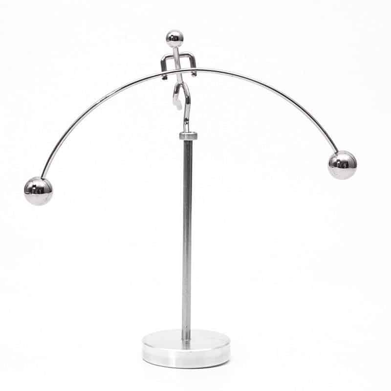 A metal magnetic balance with two spherical weights hanging from a curved metal arm, illustrating magnetic forces and equilibrium principles.