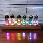 Modern Nixie tube clock displaying vibrant colors with illuminated digits on a wooden base, perfect for science decor and educational purposes.