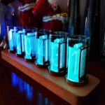 Nano LED light tubes glowing blue on wooden base, ideal for science decor and educational displays.