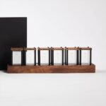 Miniature glass display case set with wooden lids and black metal frames, arranged on a wooden base.