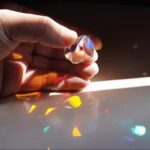 Elegant glass prism creating vibrant rainbow light patterns through refraction.
