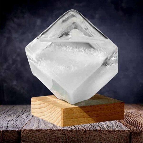 Transparent ice cube sculpture balanced on a wooden base, showcasing clarity and craftsmanship, perfect for science decor and educational displays.