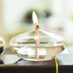 Oil lamp with a burning wick, made of clear glass, showcasing a modern take on traditional science decor.