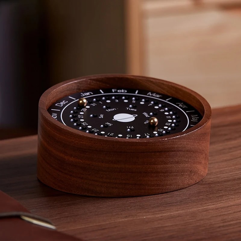 Wooden perpetual calendar with rotating month and date dials, stylish desk accessory. A wooden perpetual calendar featuring rotating month and date dials, perfect for organizing dates in a stylish and eco-friendly way on your desk.