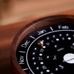 A close-up of a perpetual calendar desk clock featuring a wooden frame, displaying months, dates, and days in a scientific and educational style.