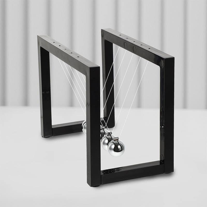 A modern Newton's Cradle with metallic balls and black frames demonstrating momentum transfer and energy conservation.