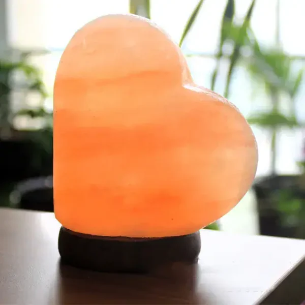 Heart-shaped Himalayan salt lamp emitting a warm, soothing glow, perfect for home decor and relaxation.