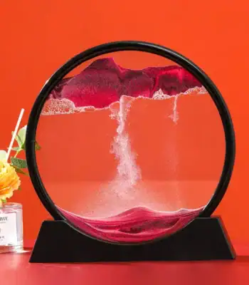 A mesmerizing magnetic levitation sand art sculpture with colorful sand flowing inside a circular frame, creating dynamic patterns against an orange background.