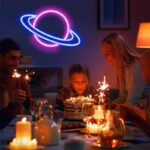 Neon planet decoration glowing above a birthday celebration with children and adults, creating a fun and educational atmosphere.