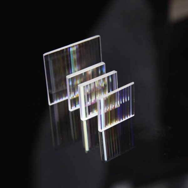 A set of four clear glass prisms with rainbow light dispersion effects, used for science experiments and educational demonstrations on light refraction and dispersion.