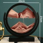 Sand art frame depicting a mountain landscape with layered sand in a circular black frame, measuring 20cm by 21cm, ideal for educational and decorative purposes.