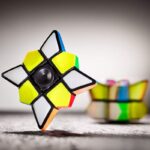 Colorful star-shaped Rubik's Cube puzzle with black edges and vibrant yellow, green, orange, and white faces, designed for brain training and educational fun.