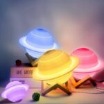Brightly illuminated planet lamps in blue, yellow, pink, and purple, designed to resemble planets with rings, creating a vibrant and educational atmosphere.