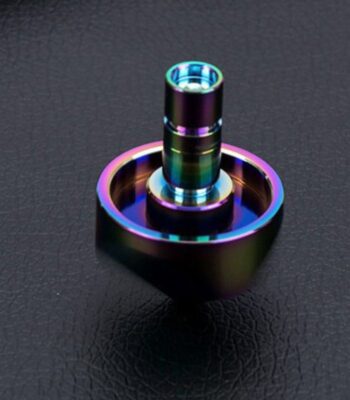 Colorful metallic spiral toy with rainbow hues on a black textured background, showcasing a modern, shiny design.