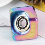 Colorful square prism-shaped speaker with rainbow metallic finish and visible circular speaker grille, ideal for science-themed decor and educational toys.