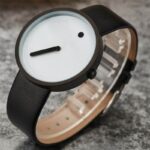 Modern minimalist wristwatch with a black leather strap, white dial, and simple design, perfect for science-inspired decor and educational gadgets.
