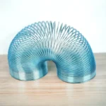 Flexible metallic coil toy demonstrating elasticity and magnetic properties, ideal for science education and decorative purposes.